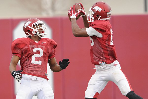 Arkansas cornerbacks D.J. Dean (2) and Cornelius Floyd work through drills during practice Saturday, Dec. 13, 2014, at the university's practice facility in Fayetteville.