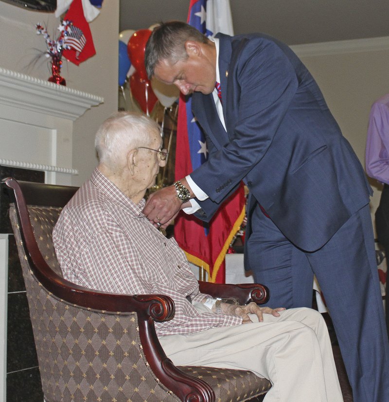 Rep. Bruce Westerman, R-4th District, pins service medals to the shirt of World War II veteran Cordy A. Ramer Jr. Wednesday during a ceremony at a Rison assisted living facility.