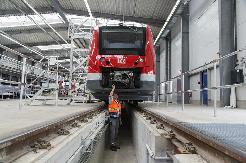 An Alstom employee checks a railway train at the Alstom SA factory in Salzgitter, Germany in August. General Electric Co. got the go-ahead from European and U.S. antitrust regulators to buy most of Alstom SA’s energy business. The deal does not include Alstom’s transportation business. 