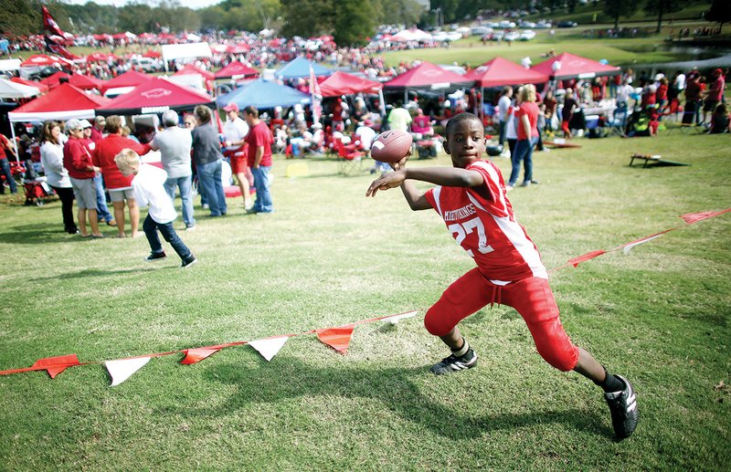 Omar Anderson plays catch in the tailgating field before the Razorback game against the University of Georgia on
October 18, 2014, at War Memorial Stadium.