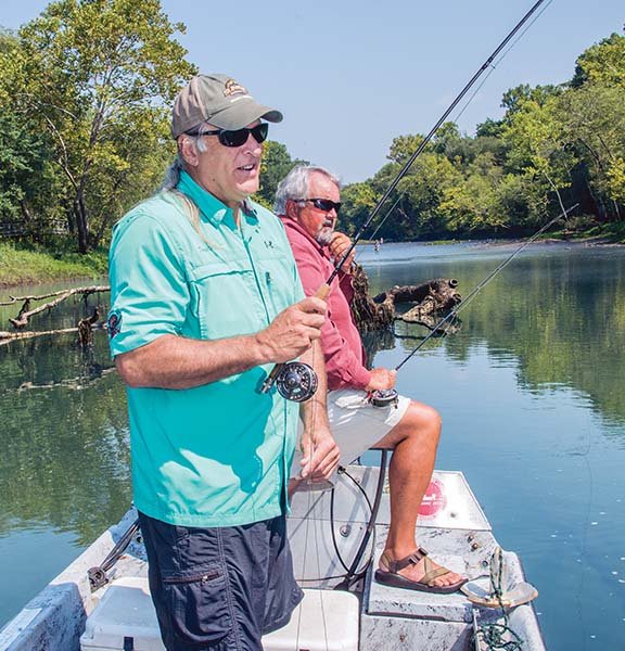 David Mitchell, left, and Lowell Myers fish from a boat on the Little Red River outside Heber Springs.