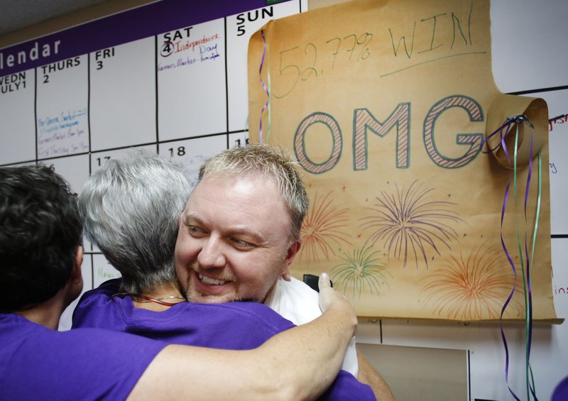 Shannon Hix, campaign manager, receives hugs Tuesday from supporters after the announcement Fayetteville’s Uniform Civil Rights Administration ordinance passed at the campaign headquarters of For Fayetteville.