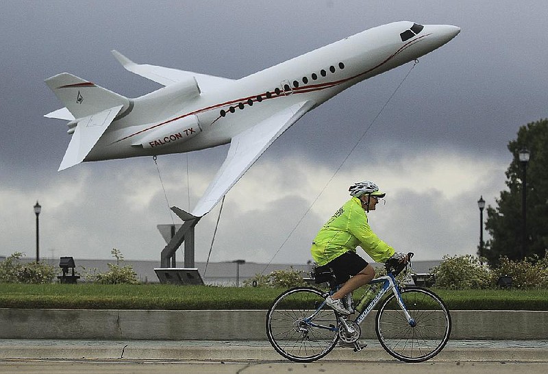 FILE — Jenny Shumate rides on the Southeast Trail past Dassault Falcon Jet with other members of the cycling club Bicycle Advocacy for Central Arkansas after a dedication ceremony to celebrate the completion of the 13-mile addition to the Arkansas River Trail System in this Sept. 9, 2015 file photo. (Democrat-Gazette staff photo)