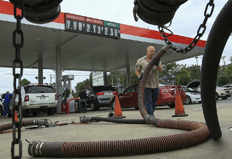 Ronnie Ballard, with Stampede Transportation, fills the tanks Wednesday at the Indian Hills Kroger at 6929 John F. Kennedy Blvd. in North Little Rock, where regular gasoline was well below $2 a gallon. 