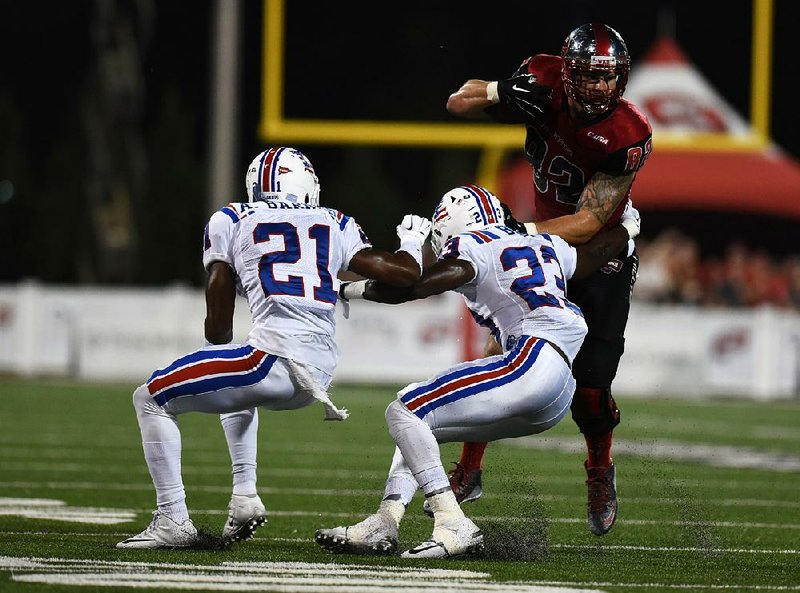 Western Kentucky tight end Tyler Higbee (right) tries to get past Louisiana Tech cornerback Adairius Barnes (21) and safety Kentrell Brice (23) during the first half of Thursday’s game in Bowling Green, Ky. The Hilltoppers won 41-38, but lost quarterback Brandon Doughty to an apparent leg injury in the third quarter.