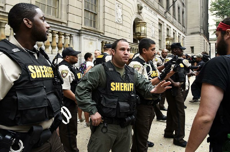 Sheriff’s deputies ask people to stay back as protesters rally Thursday outside a Baltimore court during a hearing regarding a change of venue for the trials of officers charged in the death of arrestee Freddie Gray. 