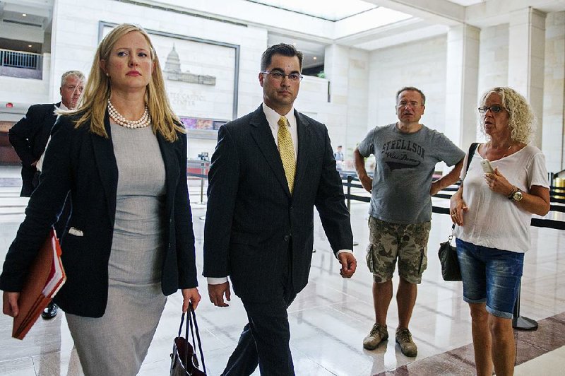 Bryan Pagliano, (center) a former State Department employee who helped set up Hillary Rodham Clinton’s private email account, leaves a House committee hearing Thursday.