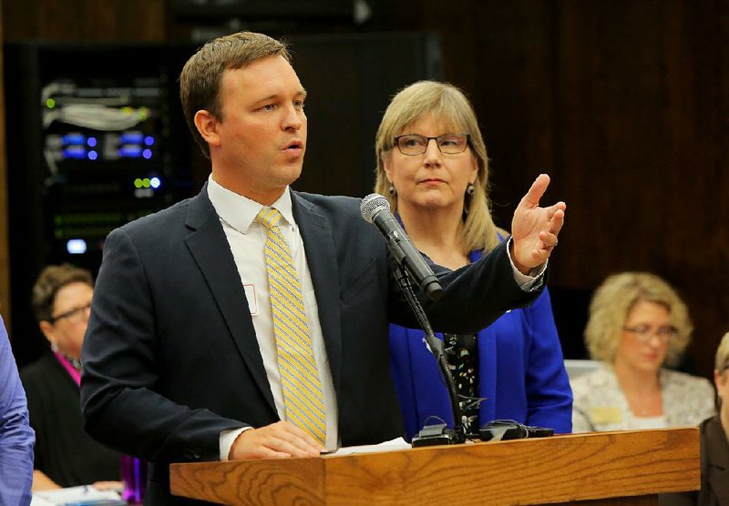 Kathy Smith, with the Walton Family Foundation, stands with Jared Henderson, managing director of Forward Arkansas, as he addresses the state Board of Education about the Forward Arkansas initiative Thursday in Little Rock. 