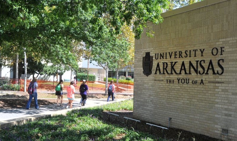 University of Arkansas students walk Thursday across campus between classes in Fayetteville. University officials announced this year’s enrollment to be 26,754, up nearly 2 percent from last year.