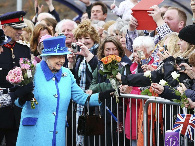 Britain’s Queen Elizabeth II, on the day she becomes Britain’s longest reigning monarch, accepts flowers from onlookers as she arrives to inaugurate the new multi million-pound Scottish Borders Railway at Tweedbank, Scotland.