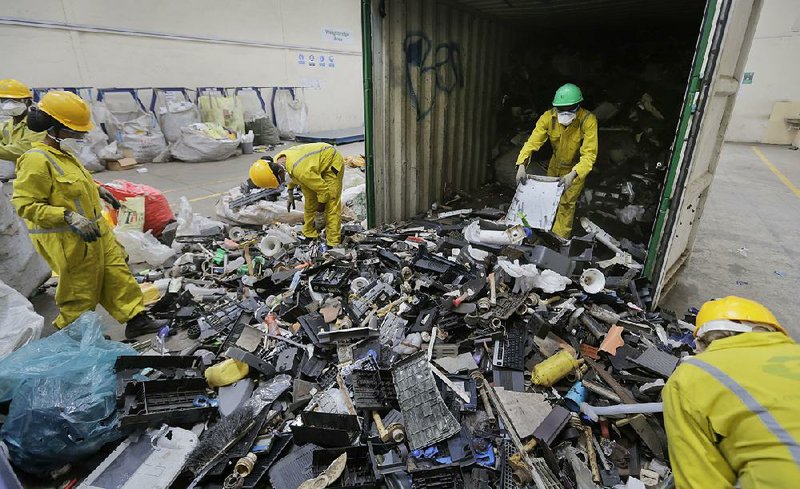 Workers unload and sort through a container full of electronic waste that was collected from a Nairobi slum in Kenya in this September 2015 file photo.