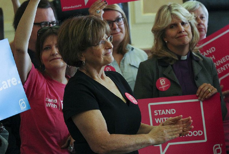 Karen Musick of Arkansas Coalition of Reproductive Justice (center) and other Planned Parenthood supporters gather Friday at the Capitol to announce a federal lawsuit against the state. 