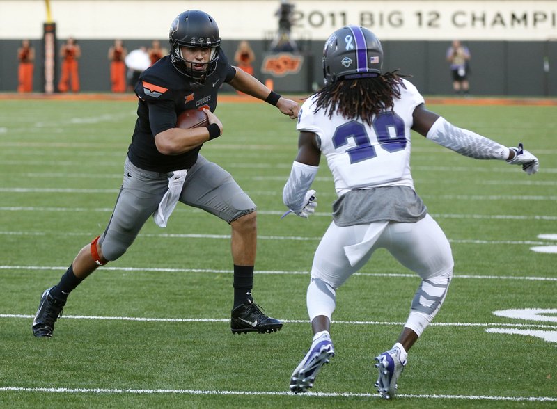 Oklahoma State quarterback Mason Rudolph (2) scrambles as Central Arkansas cornerback Tremon Smith (29) defends in the first quarter of an NCAA college football game in Stillwater, Okla., Saturday, Sept. 12, 2015.