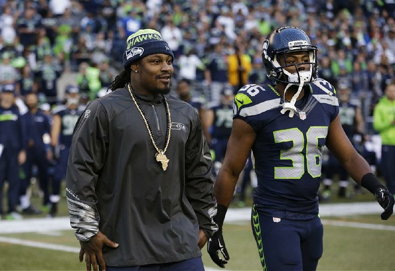 Seattle Seahawks running back Marshawn Lynch, left, stands on the sideline with defensive back Ryan Murphy, right, during the first half of a preseason NFL football game against the Oakland Raiders, Thursday, Sept. 3, 2015, in Seattle. 