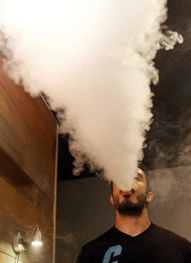 Philip LaBanca demonstrates vaping at Vapor-Riffic in Conway. Vaping is a type of open-system e-cigarette that allows users to refill their devices with e-liquid, a mix of liquid nicotine, flavorings, vegetable glycerin and propylene glycol. E-liquid with more vegetable glycerin produces a bigger “cloud” when users exhale.
		