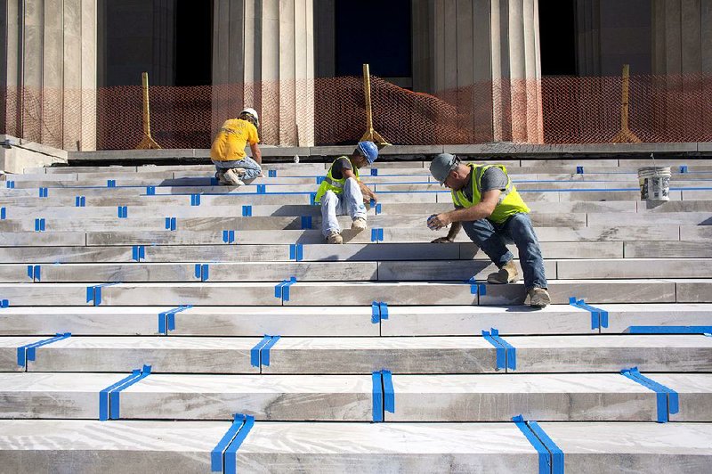 Construction workers tape up new limestone steps Monday during a news conference about Celebrity Attraction’s forthcoming productions at the Robinson Center in Little Rock. mel
