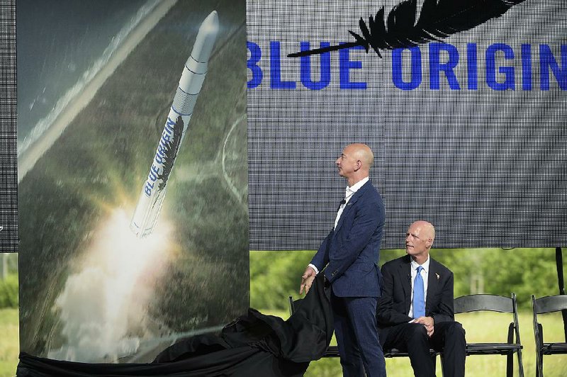 Amazon CEO Jeff Bezos (left) unveils the new Blue Origin rocket design as Florida Gov. Rick Scott watches during a news conference at the Cape Canaveral Air Force Station in Cape Canaveral, Fla., Tuesday.