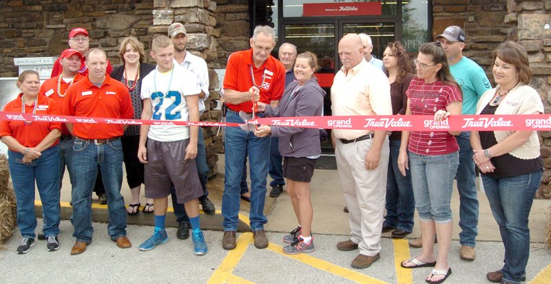 Photo by Mike Eckels Chris Cole (center, left), store manager and Margo Barnes (center, right), chamber president, cut the ribbon, formally opening the Farmers Co-op True Value Hardware store in Decatur on Sept. 11.