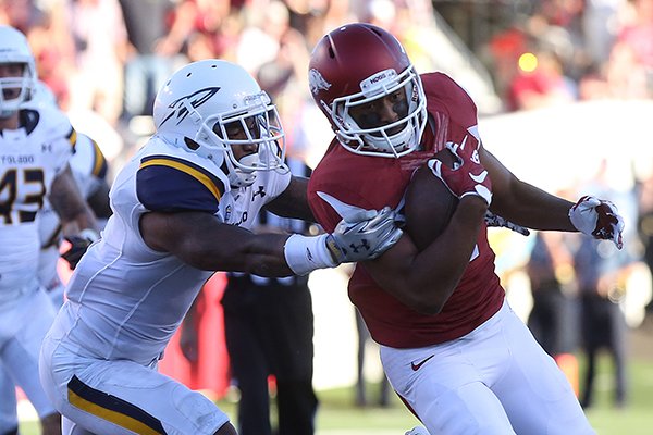 Arkansas receiver Jared Cornelius is tackled by Toledo defender Cheatham Norrils in the fourth quarter of a game Saturday, Sept. 12, 2015, at War Memorial Stadium in Little Rock. 