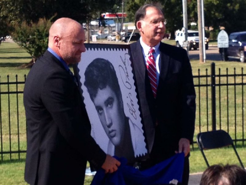 David Camp (left), the U.S. Postal Service manager for Arkansas, and U.S. Sen. John Boozman, R-Ark., unveil the Elvis Presley commemorative Forever stamp Friday in Walnut Ridge. 