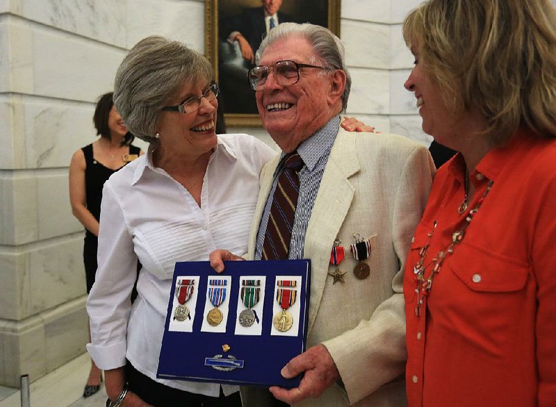 Courtney Renshaw, 92, a World War II veteran, celebrates with his daughters, Kay Fellone (left) and Dena Gunderson, after he was awarded several medals, including a Bronze Star, during the National POW/MIA Recognition Day ceremony Friday at the state Capitol. 