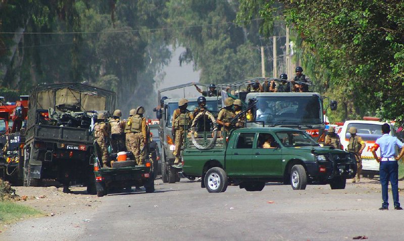 Pakistani troops surround an air force compound near Peshawar after militants attacked Friday.