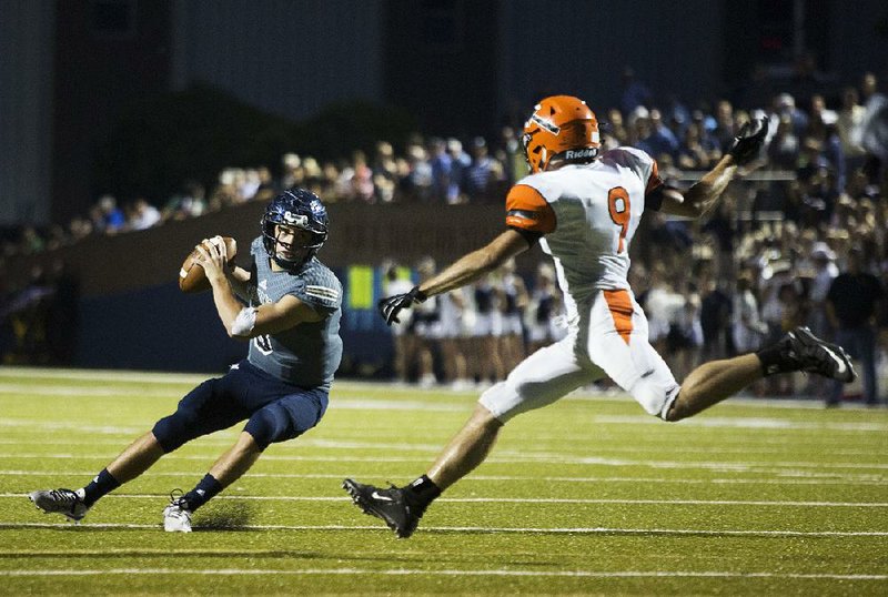 Pulaski Academy quarterback Layne Hatcher (left) tries to get around Warren’s Peyton Hargis during Friday night’s game. Hatcher completed 22 of 27 passes for 535 yards and 7 touchdowns to lead the Bruins to a 71-40 victory. For more photos, visit arkansasonline.com/galleries.