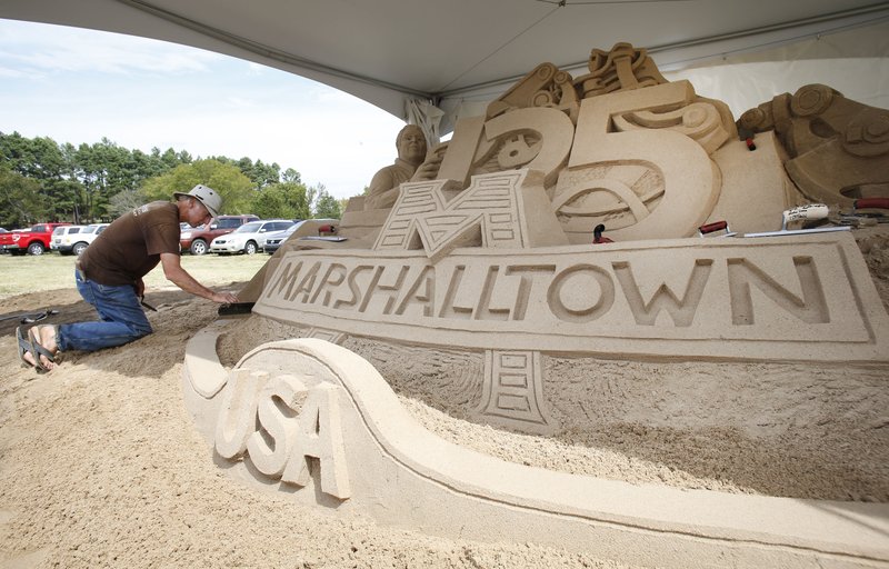 NWA Democrat-Gazette/DAVID GOTTSCHALK Kirk Rademaker with Sand Guys International puts the final touches on a sand sculptor Friday at Marshalltown Company in Fayetteville. The company, in Fayetteville since 1982, celebrated it&#8217;s 125th year in business.