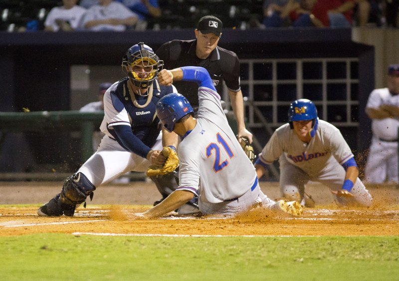 Matt Olson of Midland slides under the tag of Northwest Arkansas’ Zane Evans during Friday’s game 3 for the Texas League Championship Series at Arvest Ballpark in Springdale.