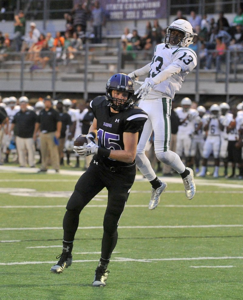 Drake Wymer, Fayetteville receiver, scores a touchdown in front of Muskogee, Okla., defender Tavian Davis during the first half of Friday’s game in Fayetteville.