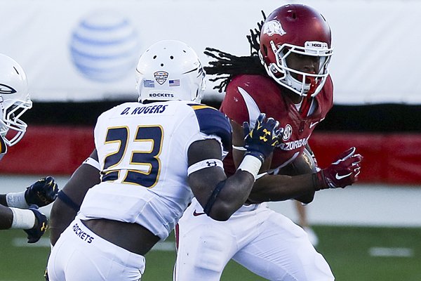 Arkansas' Keon Hatcher looks for an opening in Toledo's defense with De Jaun Rogers defending before being forced out of bounds during their game at War Memorial Stadium Saturday, Sept. 12, 2015.
