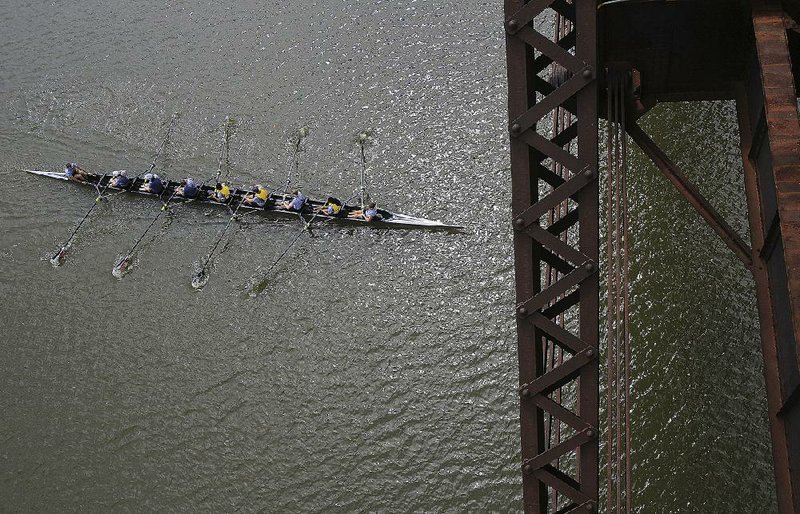 Rowers pass under the Clinton Presidential Park bridge between Little Rock and North Little Rock on Saturday as they compete in the Mixed Open 8 category at the Six Bridges Regatta on the Arkansas River. More photos are available at arkansasonline.com/galleries. 

