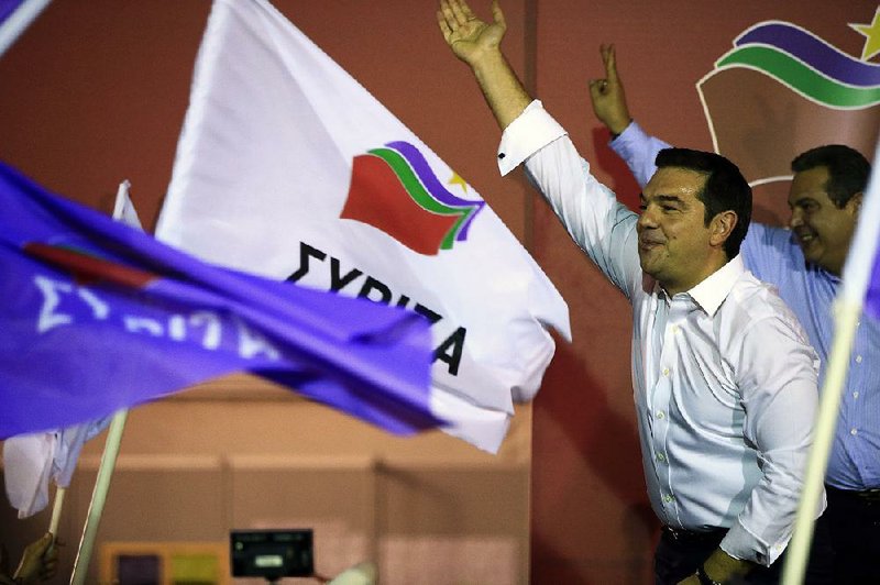 Syriza party leader Alexis Tsipras (left) greets supporters as Panos Kammenos, the leader of the Independent Greeks party, makes the victory sign after Tsipras’ general election victory Sunday in Athens. Tsipras said he would renew his partnership with Kammenos in a coalition government.