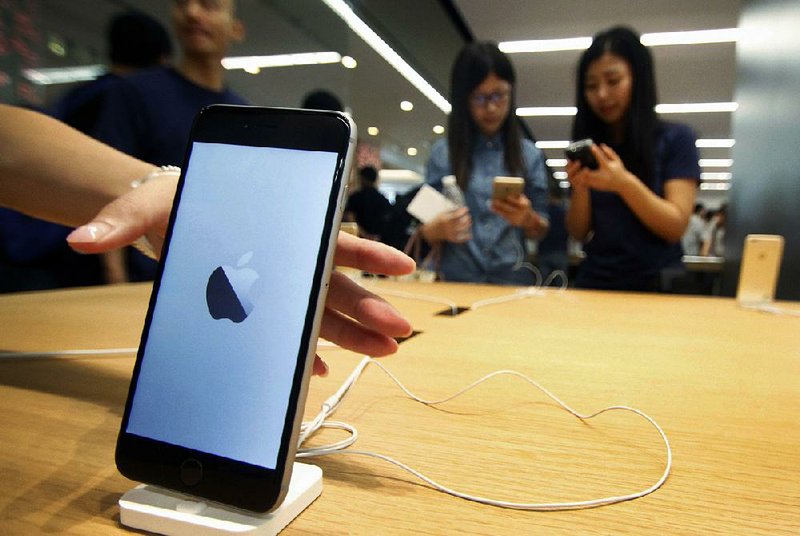 Chinese women try iPhones at a new Apple Store in Nanjing in east China’s Jiangsu province Saturday.