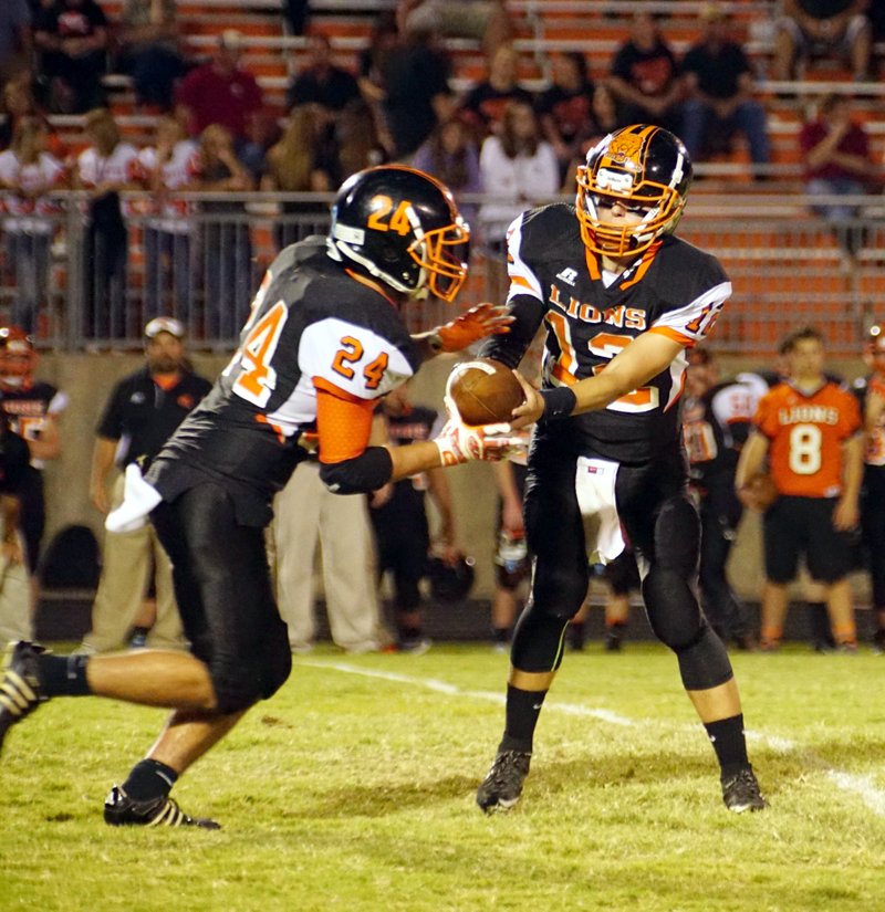 Photo by Randy Moll Bryce Moorman, Gravette quarterback, hands off the ball to Jordan Burnett during play against the Bulldogs from Jay, Okla., in Lion Stadium on Friday, Sept. 18, 2015.
