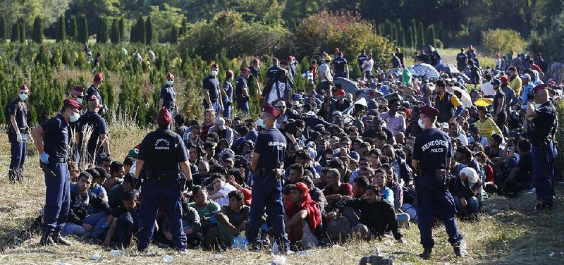 Migrants wait to be escorted to a train after crossing the Hungarian border from Croatia near the village of Zakany, Hungary. Hungarian Prime Minister Viktor Orban has worked to stymie the influx of mostly Muslim asylum seekers, saying they are on a campaign to de-Christianize Europe.