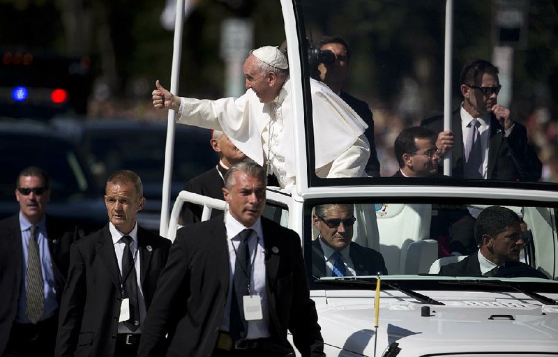 Under the wary eye of his security detail, Pope Francis greets the crowd Wednesday during a parade around the Ellipse near the White House.