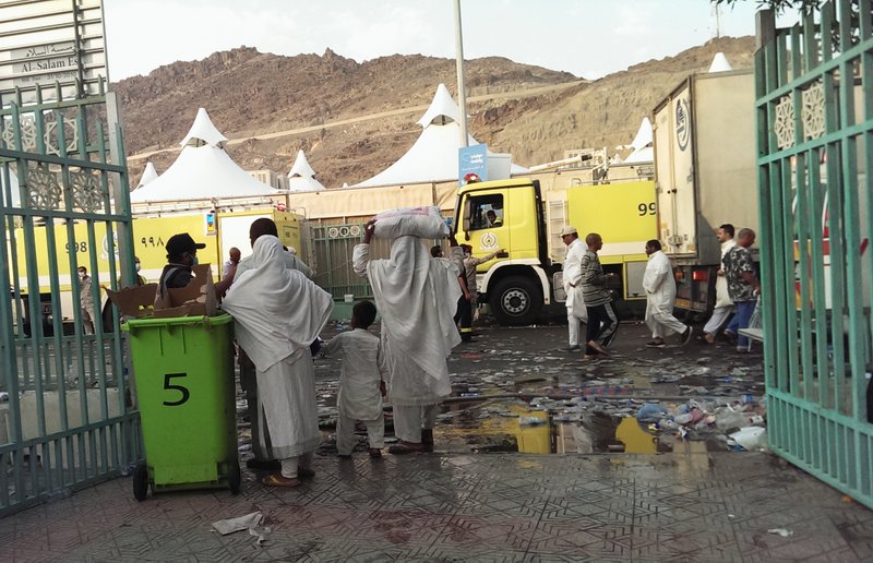 Muslim pilgrims watch people working on the site where hundreds of other pilgrims were crushed and trampled to death during the annual hajj pilgrimage in Mina, Saudi Arabia, Thursday, Sept. 24, 2015. The crush killed hundreds of pilgrims and injured hundreds more in Mina, a large valley on the outskirts of the holy city of Mecca, the deadliest tragedy to strike the pilgrimage in more than two decades. (AP Photo)
