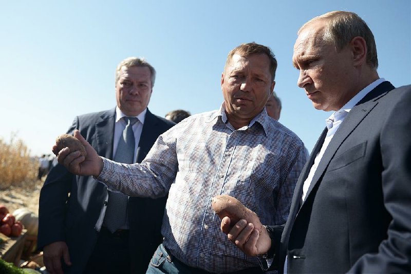 Russian President Vladimir Putin (right) visits a farm in the village of Shaminka in Rostov region of Russia on Thursday. 