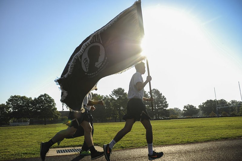 Airmen from the 19th Medical Group run on the track with a POW/MIA flag Sept. 18 at the Little Rock Air Force Base. The 24-hour run was held as part of National Prisoner of War/Missing in Action Recognition Day.