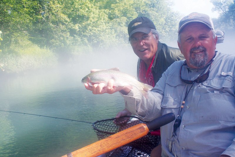 In this file photo Lowell Myers of Sore Lip ’Em All Guide Service, foreground, and David “Mountain Man” Mitchell show off one of the rainbow trout caught during a trip to the Little Red River near Pangburn.