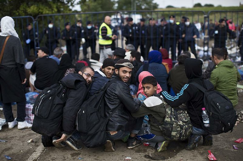 Huddling in the chill, migrants wait Friday to be cleared to cross farther into Croatia from Serbia at the border in Babska, Croatia.
