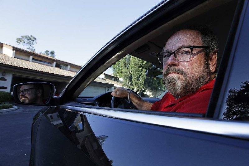 Bob Rand poses for a photo in his 2014, fully loaded Volkswagen diesel Passat last week, in Pasadena, Calif.