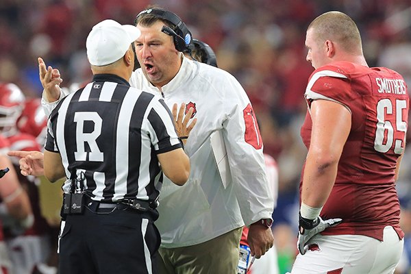 Arkansas coach Bret Bielema (center) argues with referee Hubert Owens during the first half of the Razorbacks' 28-21 loss to Texas A&M on Saturday, Sept. 26, 2015, at AT&T Stadium in Arlington, Texas. 