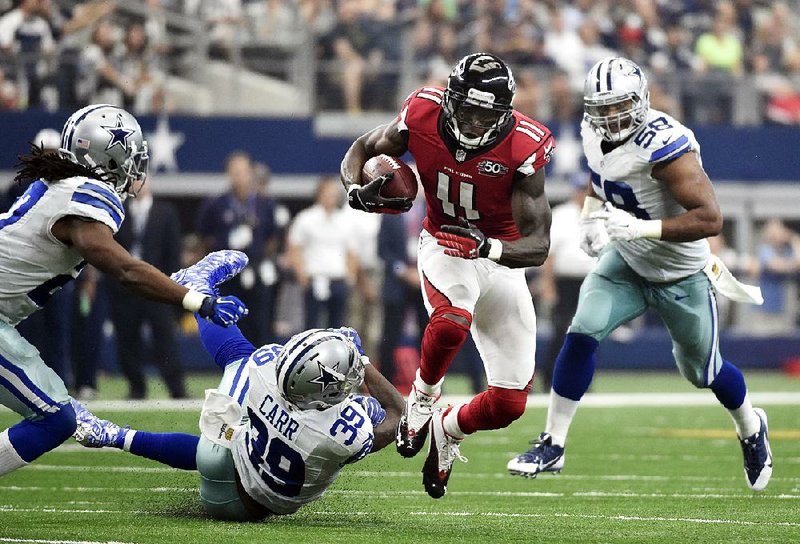 Atlanta wide receiver Julio Jones (1) breaks away from Dallas defenders Brandon Carr (39) and Jack Crawford (58) during the second half of Sunday’s game. Jones caught 12 passes for 164 yards and 2 touchdowns in the Falcons’ 39-28 victory.
