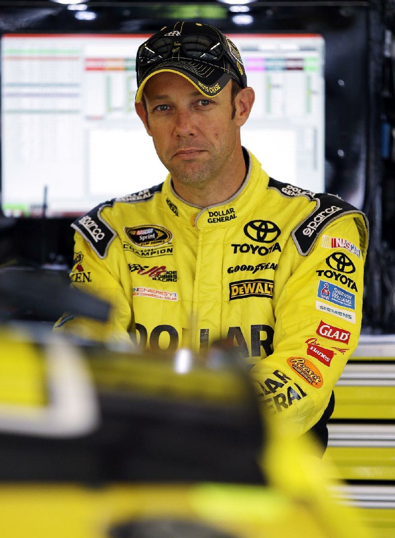 Matt Kenseth looks at his car in the garage during practice for the NASCAR Sprint Cup Series auto race at Chicagoland Speedway, Friday, Sept. 18, 2015, in Joliet, Ill.