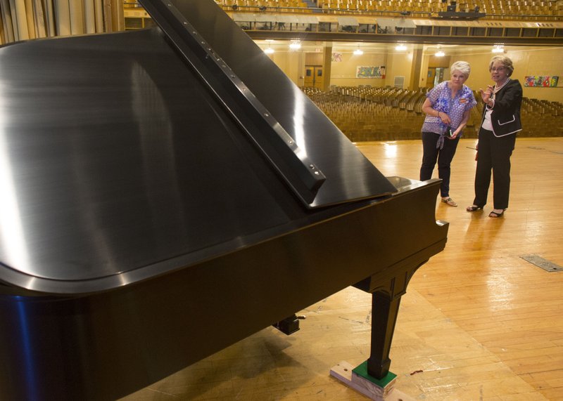 Julie Keller, left, Tiger Foundation board member, speaks Sept. 10 with Central High School Principal Nancy Rousseau as they look over a 1927 Steinway piano at Central High School in Little Rock. The piano took 18 months to restore by a team lead by Mike Anderson’s Piano and Music Company in Cabot after a lifetime with the school.