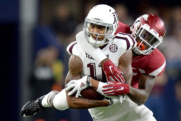 Texas A&M's Josh Reynolds (11) is tackled by Arkansas' Ryan Pulley (10) after a catch for a first down during an NCAA college football game Saturday, Sept. 26, 2015, in Arlington, Texas. Texas A&M won 28-21 in overtime. (Sam Craft/The Bryan-College Station Eagle)