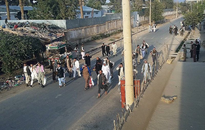Taliban prisoners walk down a street after their comrades released them from the main jail in Kunduz, north of Kabul, Afghanistan, on Monday. 