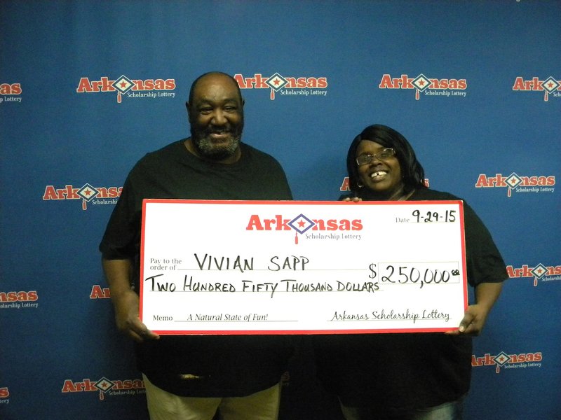 Little Rock resident Vivian Sapp holds a $250,000 check from the Arkansas Scholarship Lottery on Tuesday, Sept. 29, 2015, with her husband, McKinley Sapp.